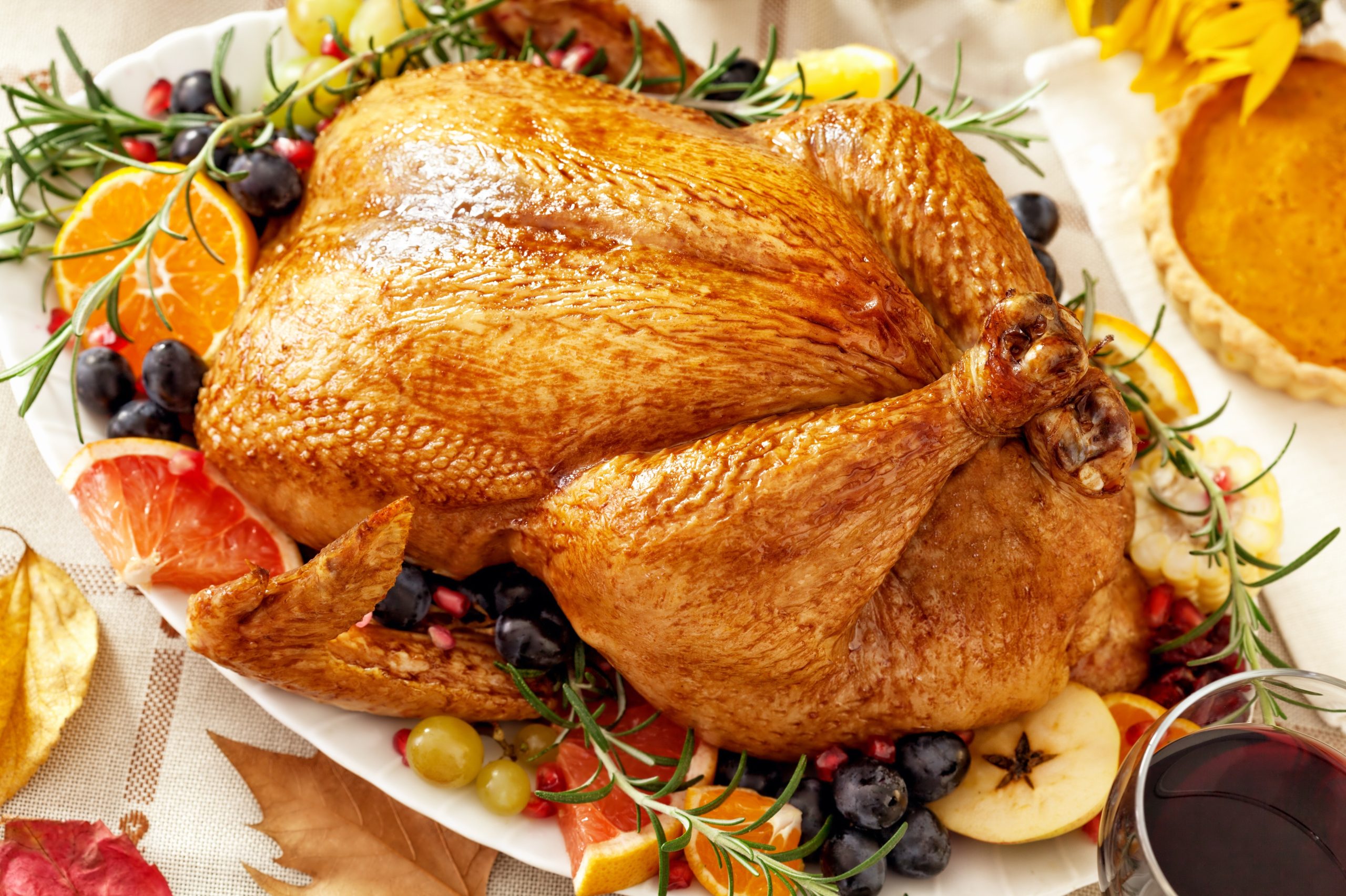 Cooked turkey on a plate with food in the center of a dining room table